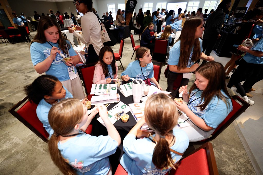 students at a table taste testing different foods