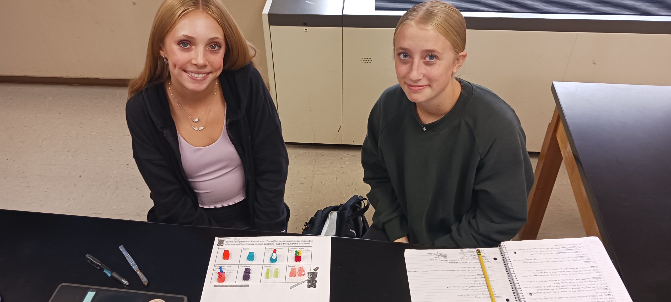 kids sitting at their desk doing an experiment together