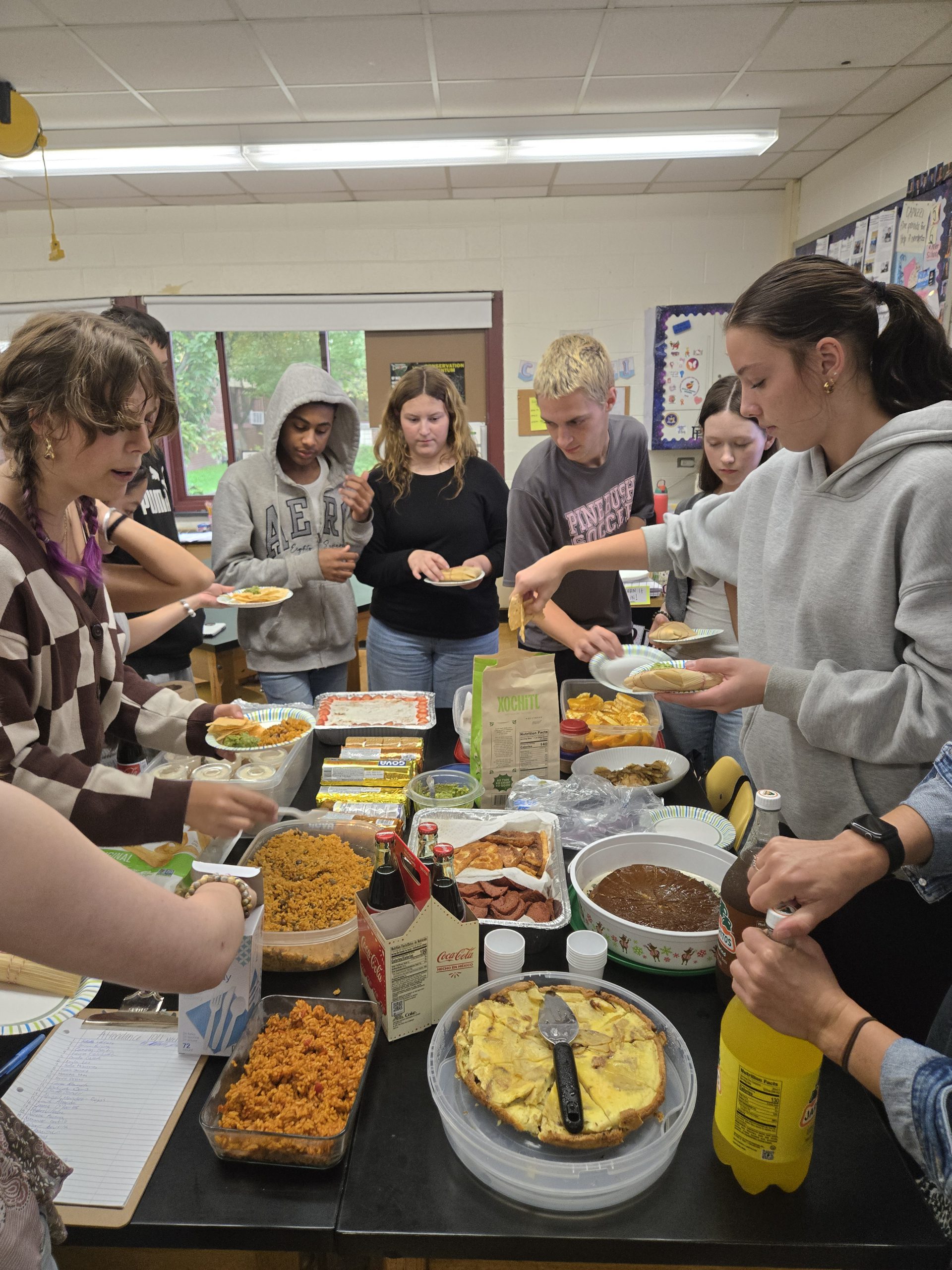teenagers grabbing food on a table