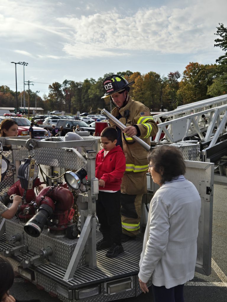 firefighter showing a child fire truck equipment