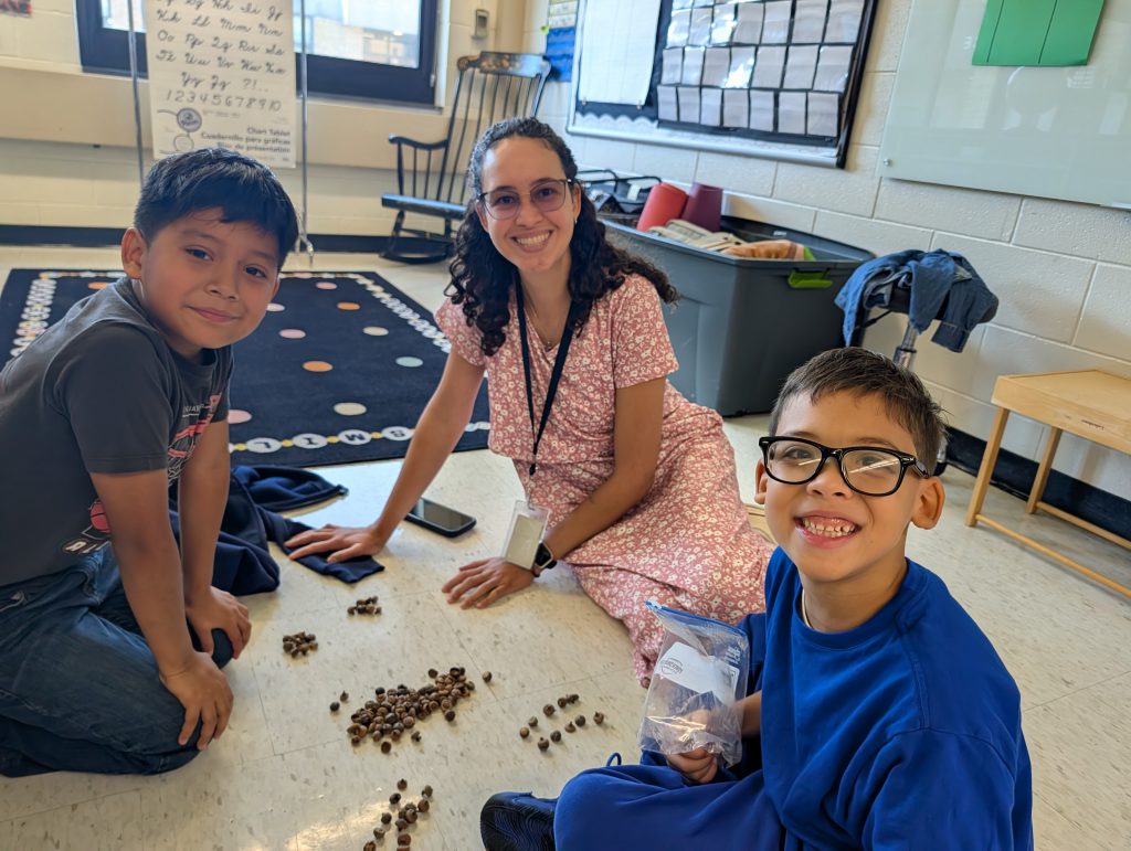 kids sitting with their teacher on the floor in class
