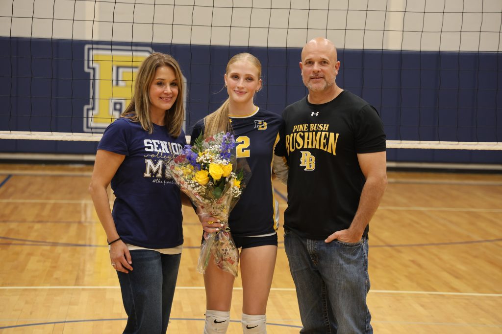 volleyball player with her parents standing for picture