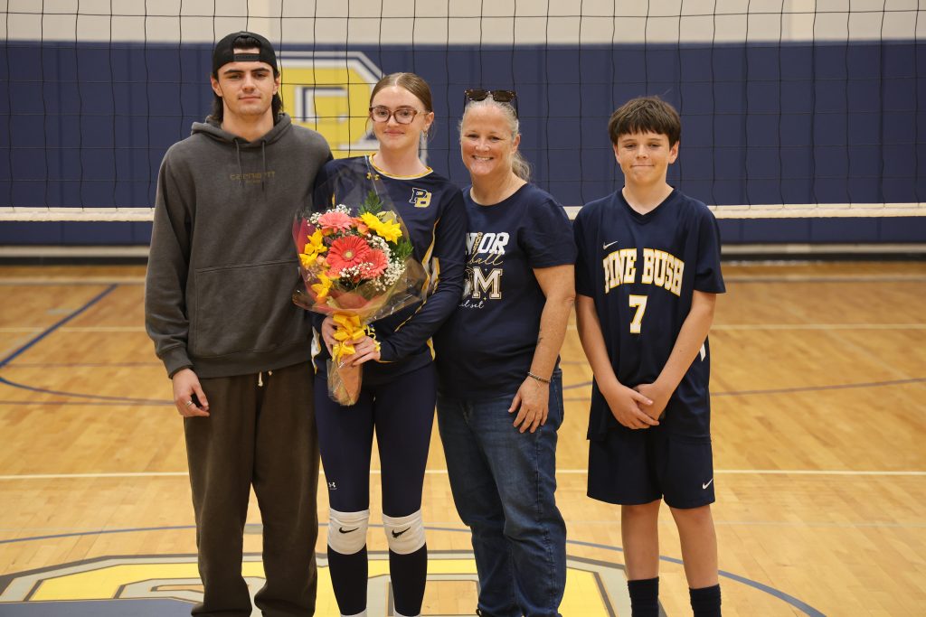 volleyball player with her parents standing for picture