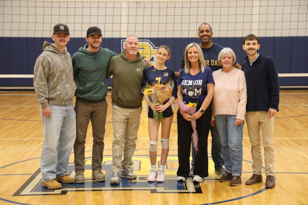 volleyball player with her parents standing for picture