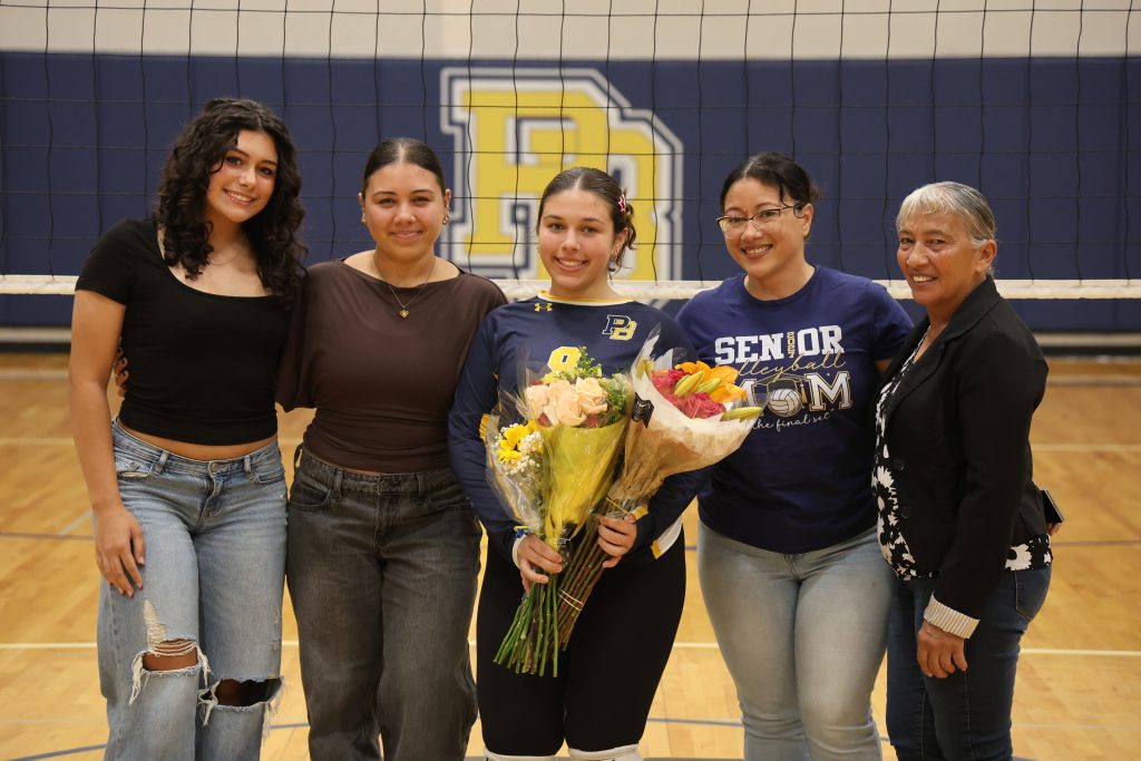volleyball player with her parents standing for picture