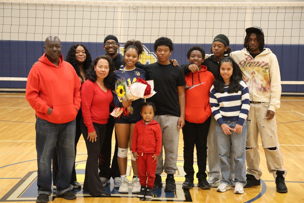 volleyball player with her parents standing for picture
