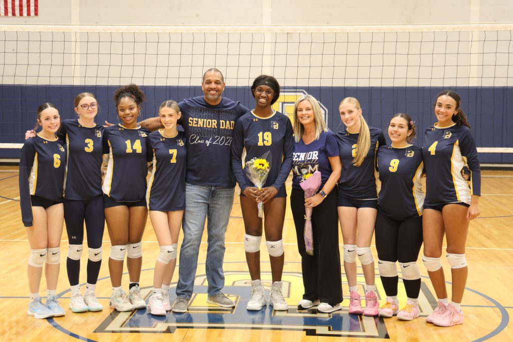 volleyball player with her teammates for picture