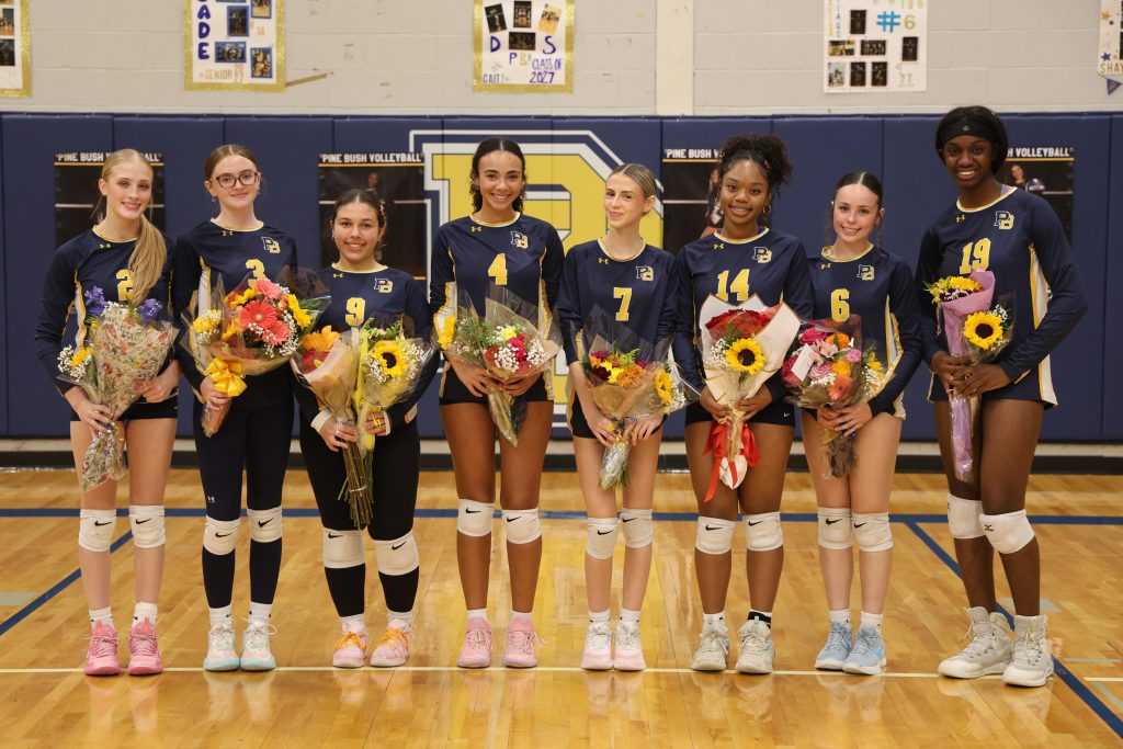 volleyball player with her teammates standing for picture