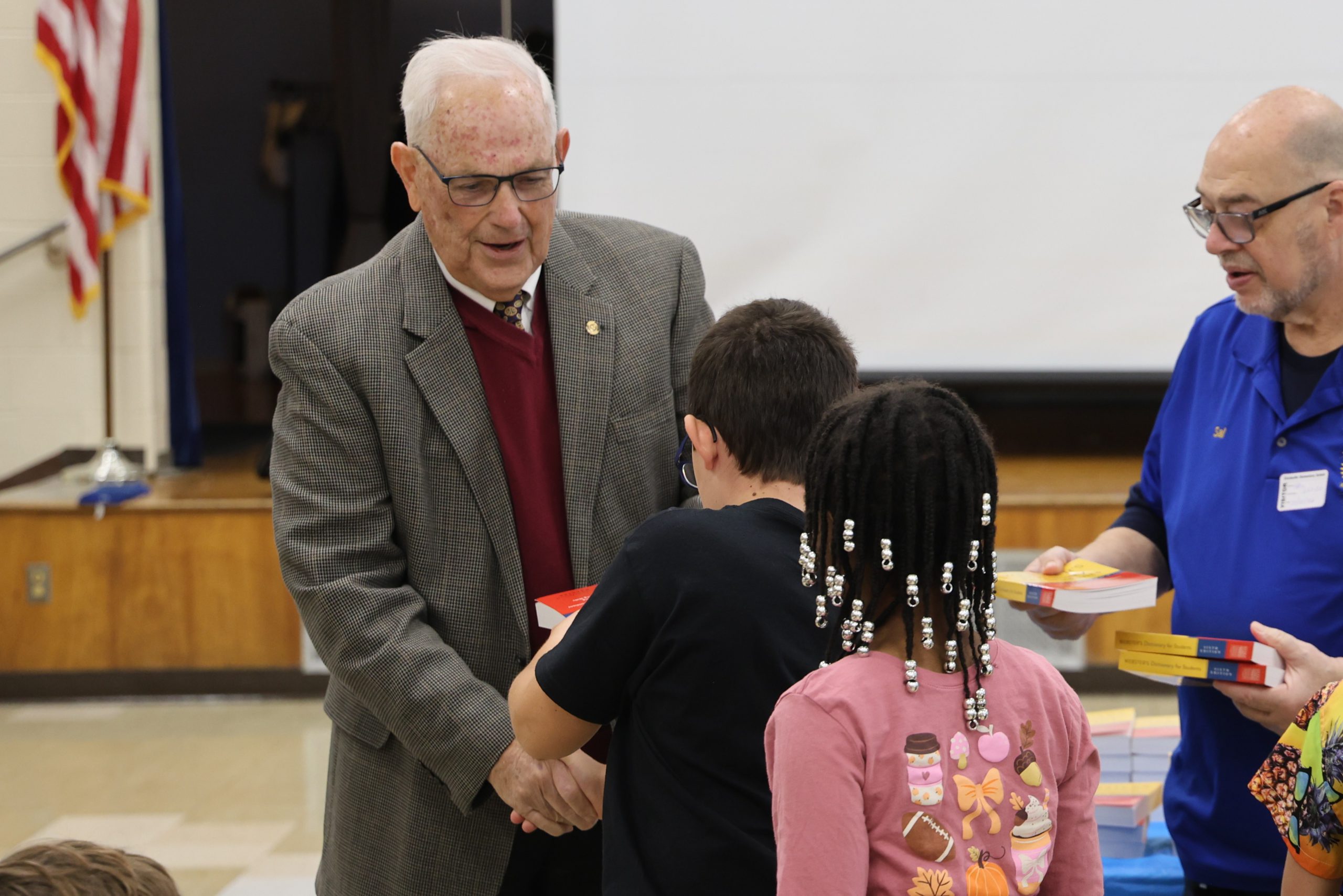 man shaking an elementary students hand