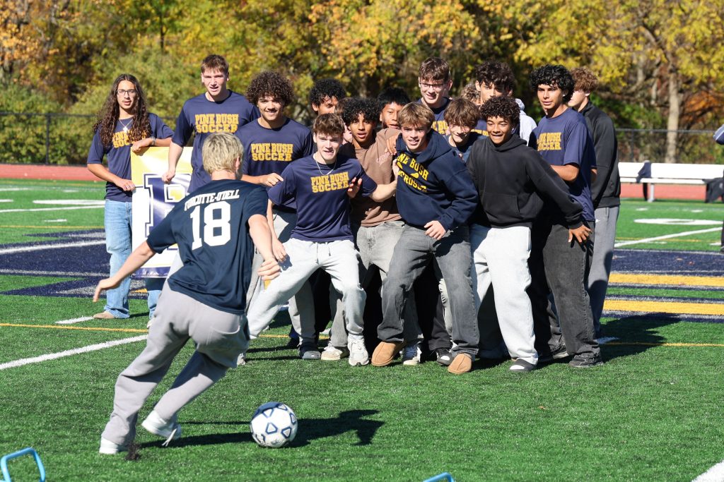 soccer player kicking a ball toward his teammates