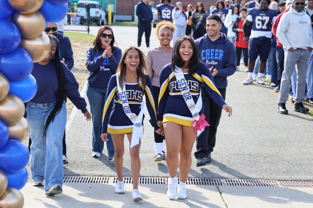 two cheerleaders walking together with their family