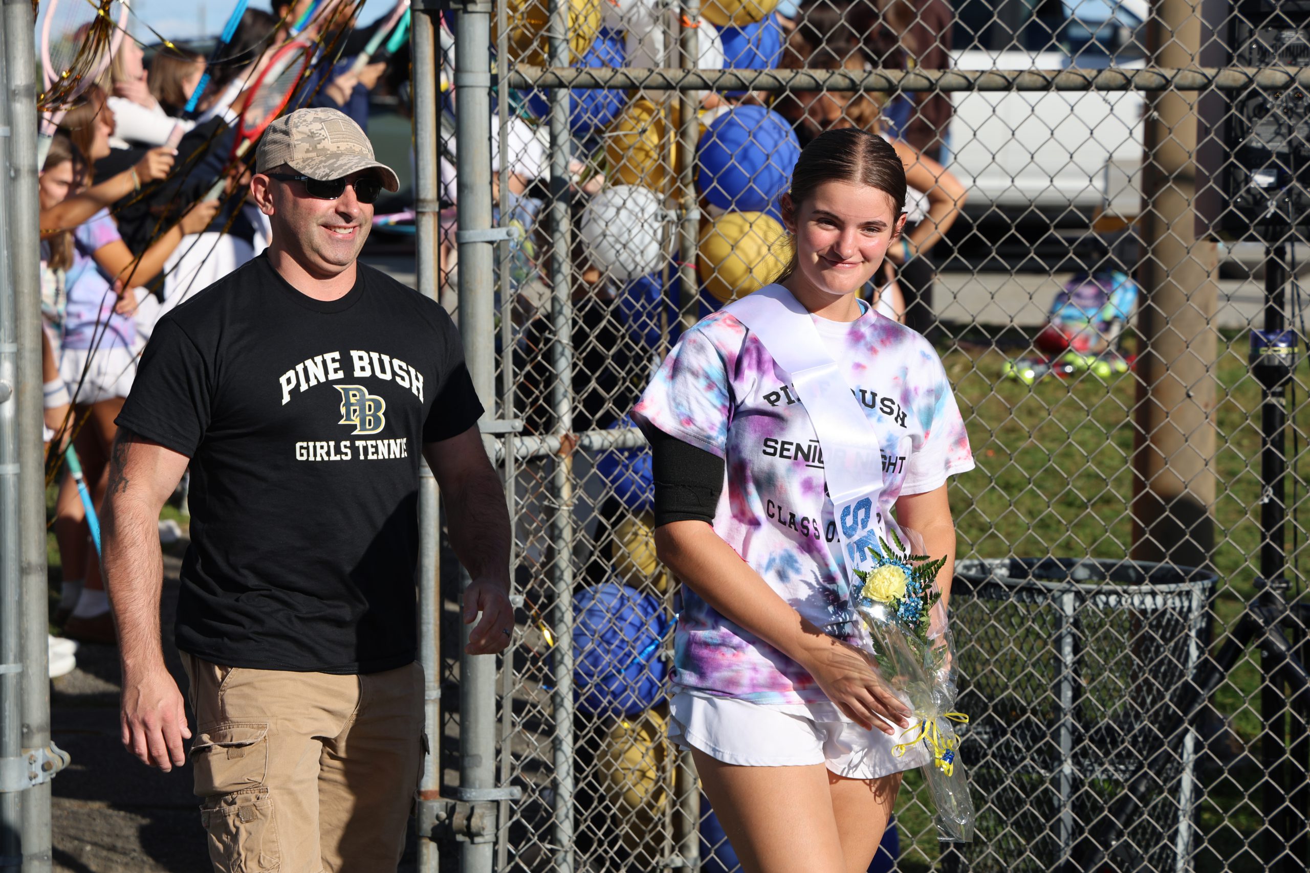 girl walking out with flowers on a tennis court