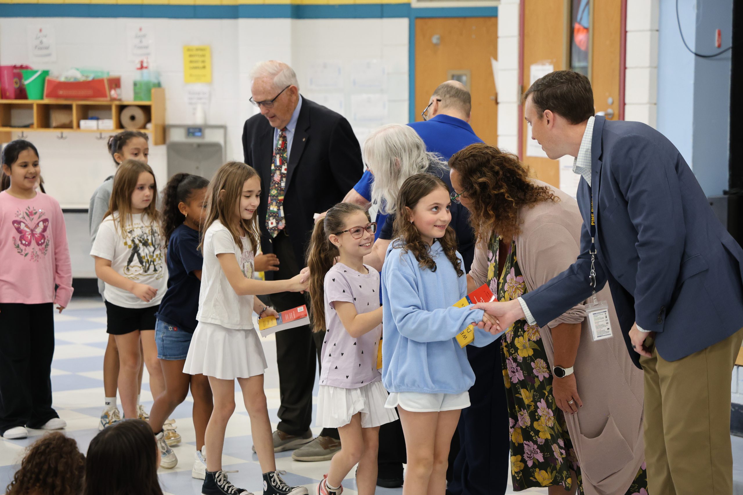 man shaking an elementary student's hand