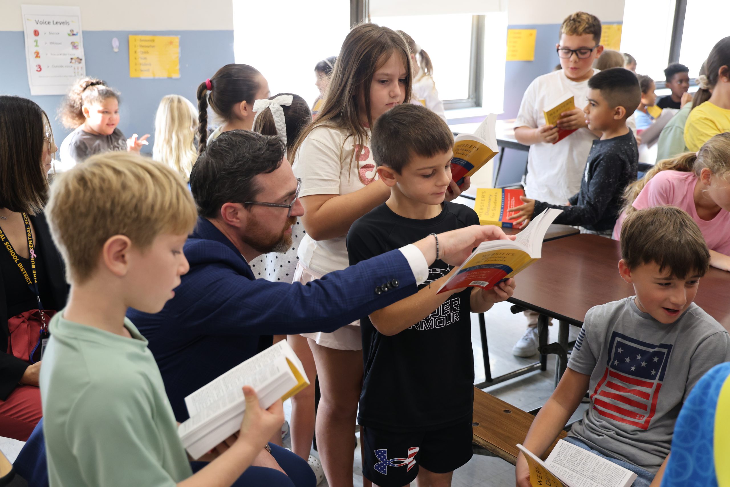 man helping a student read a dictionary