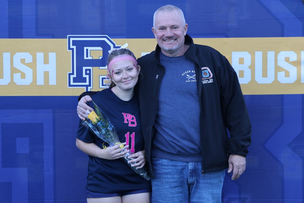 high school soccer player standing with their parents