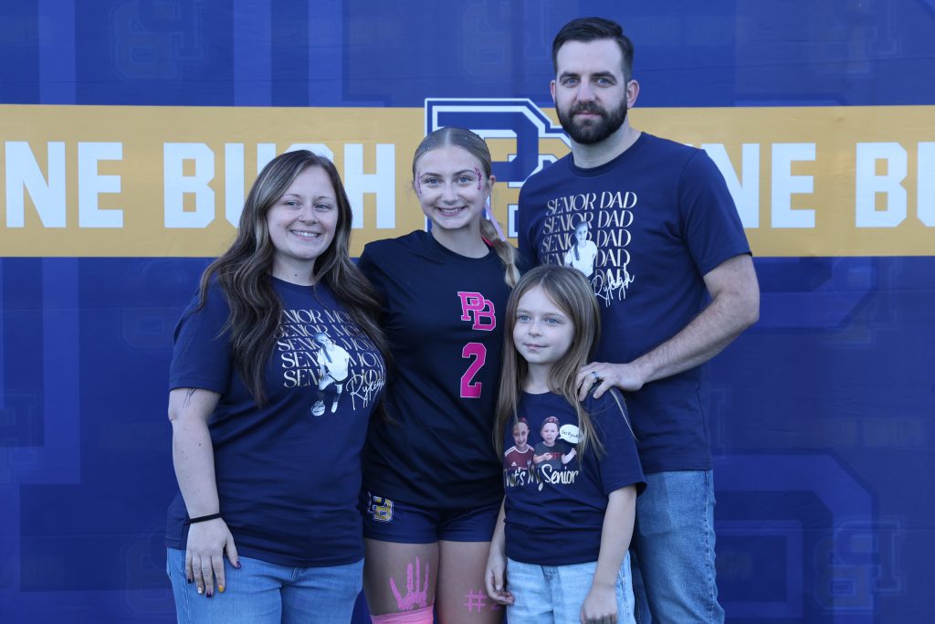 high school soccer player standing with their parents