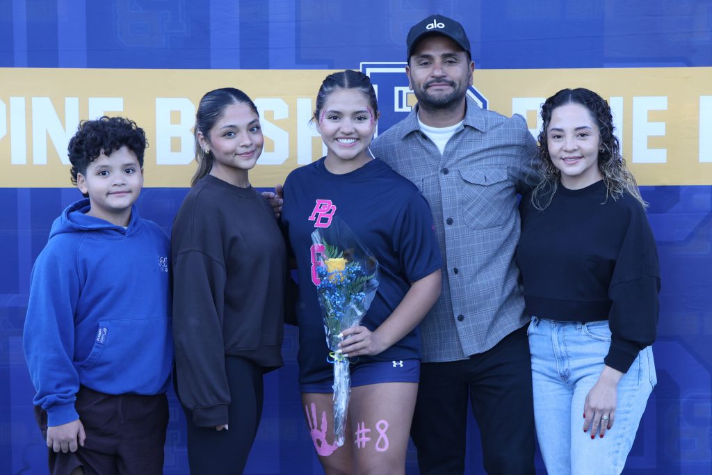 high school soccer player standing with their parents
