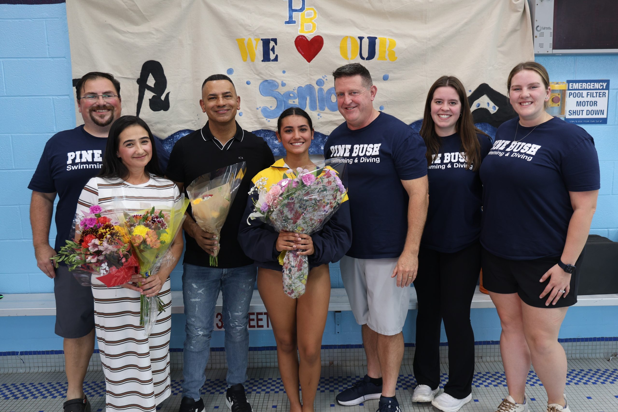 swimming and diving player surrounded by her coaches and parent