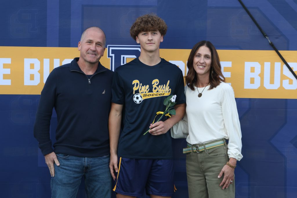 boys soccer player standing with his parents