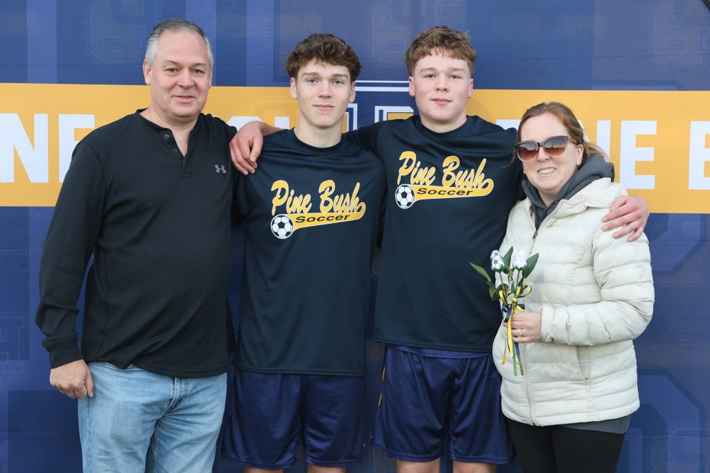 boys soccer player standing with his parents