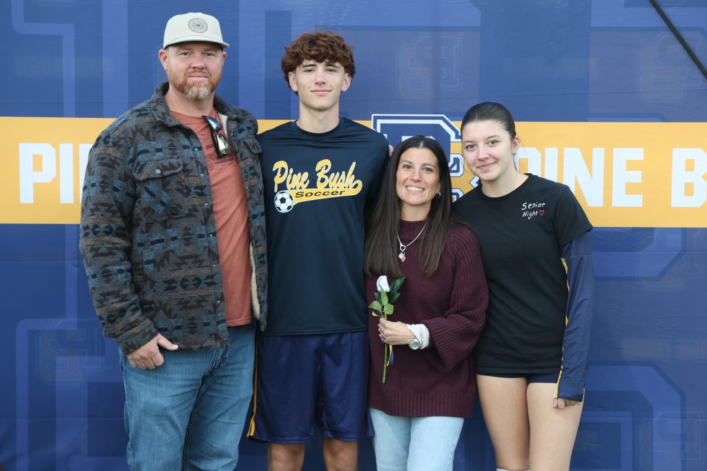boys soccer player standing with his parents