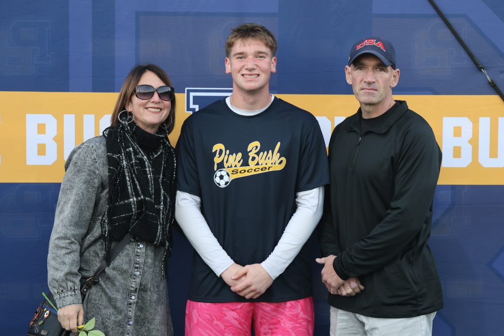 boys soccer player standing with his parents