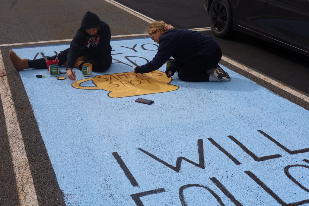students painting on a parking spot