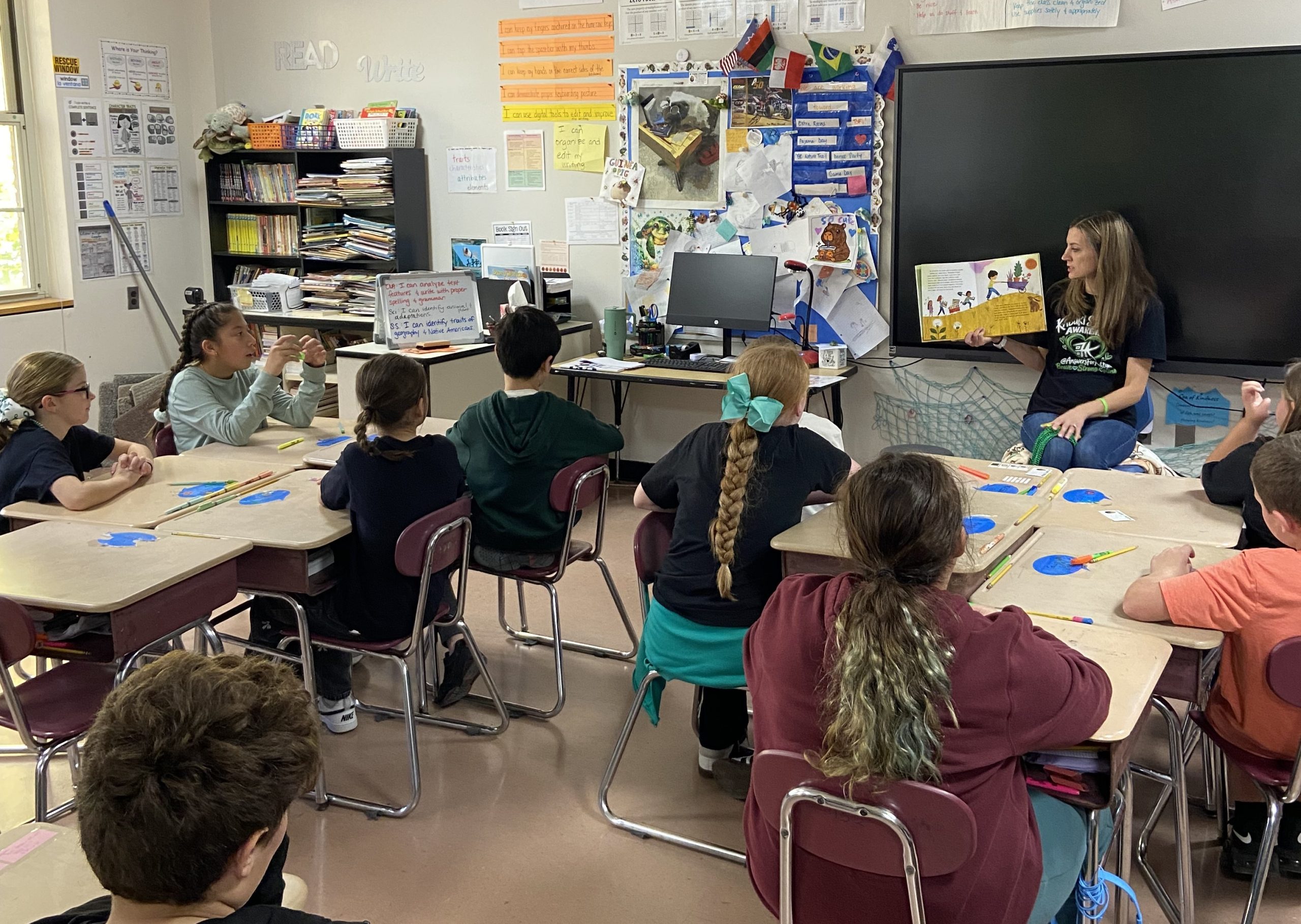 parent reading a book to students in class